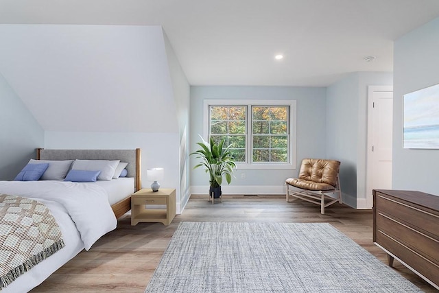 bedroom with recessed lighting, wood finished floors, and baseboards