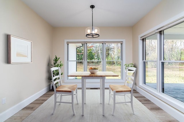 dining space with a chandelier, baseboards, and wood finished floors