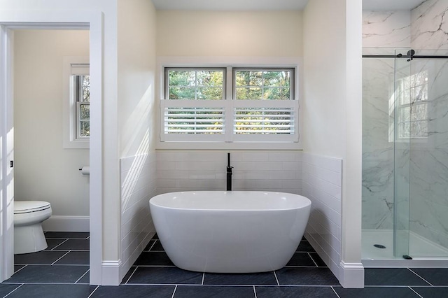 full bathroom with toilet, a soaking tub, tile patterned flooring, and a marble finish shower