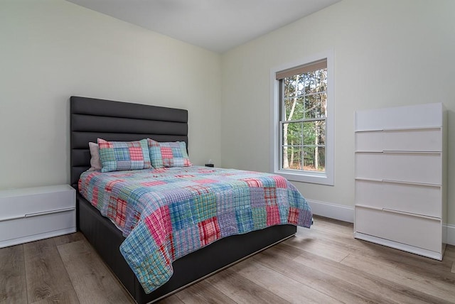 bedroom featuring wood finished floors and baseboards