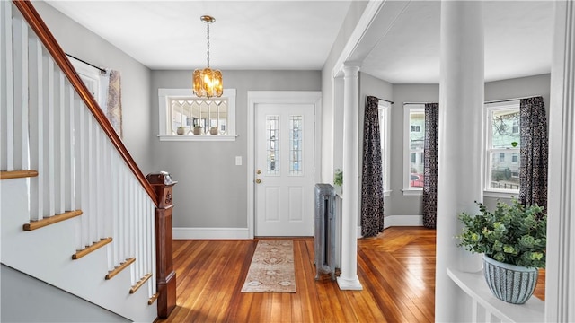 entrance foyer with stairs, hardwood / wood-style floors, decorative columns, and baseboards