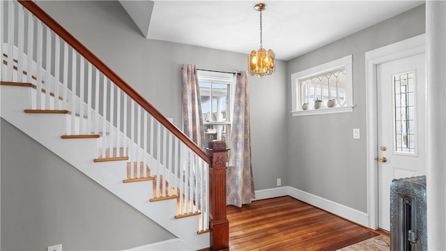 foyer with a chandelier, baseboards, and wood finished floors