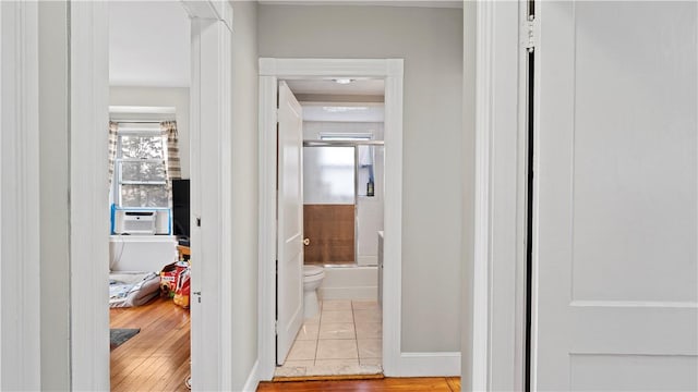 corridor with baseboards and tile patterned floors