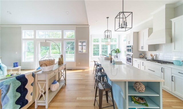 168 Explorer Dr, North Kingstown, RI 02874 - kitchen featuring stainless steel gas cooktop, custom exhaust hood, open shelves, backsplash, and a sink