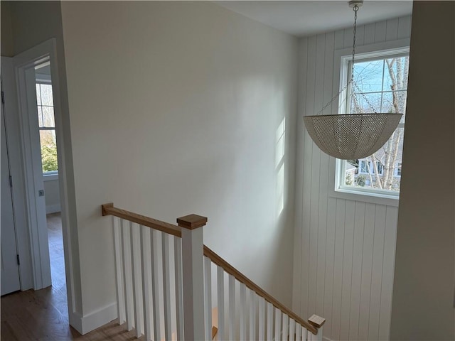 stairway with wood finished floors and baseboards