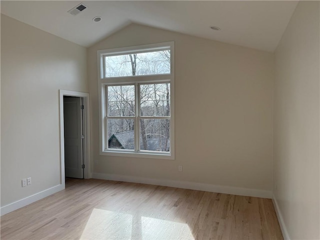 bonus room featuring light wood-type flooring, baseboards, visible vents, and vaulted ceiling