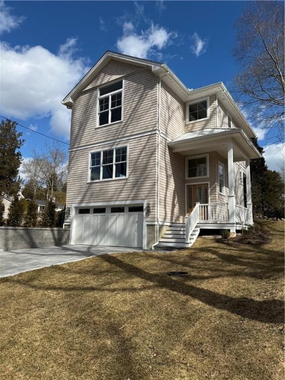 back of house featuring concrete driveway, a yard, and an attached garage