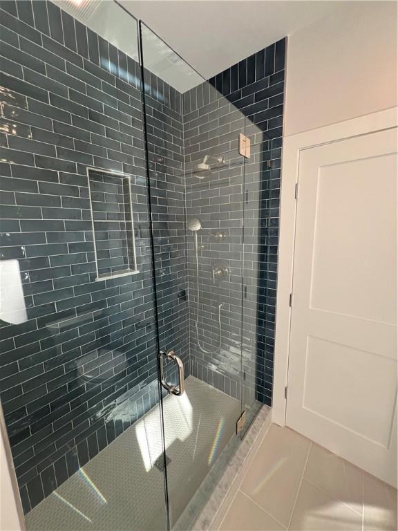 full bath with a stall shower and tile patterned flooring