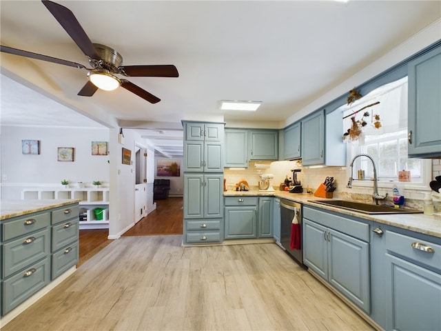 kitchen featuring decorative backsplash, dishwasher, light wood-style flooring, and a sink