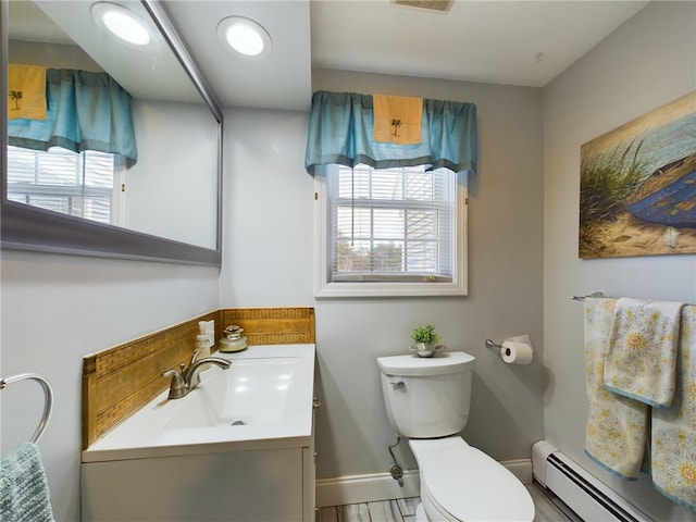 bathroom featuring toilet, baseboard heating, a wealth of natural light, and vanity