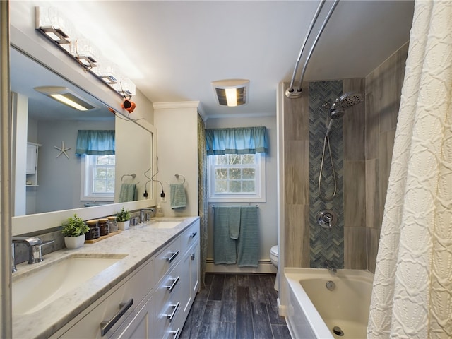 full bath with plenty of natural light, a sink, toilet, and wood finished floors