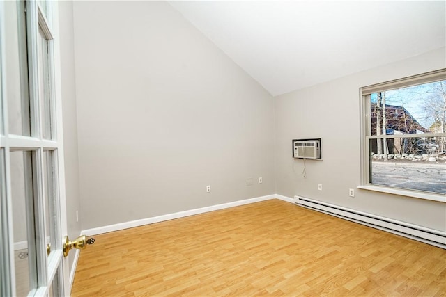 empty room featuring baseboards, vaulted ceiling, baseboard heating, light wood-type flooring, and a wall mounted air conditioner