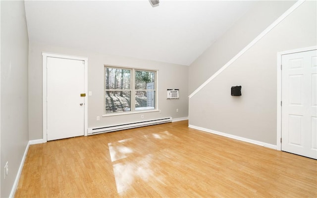 interior space with lofted ceiling, a baseboard radiator, baseboards, and light wood-style flooring