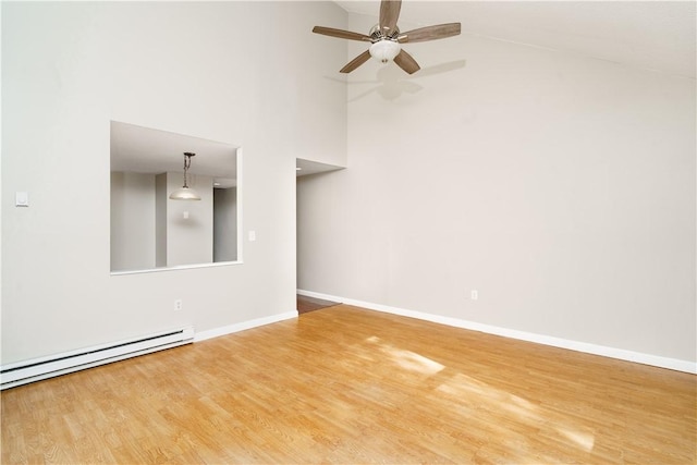 unfurnished room with a baseboard radiator, ceiling fan, baseboards, and wood finished floors