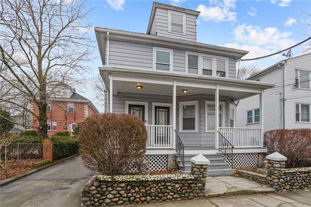 traditional style home with covered porch and fence