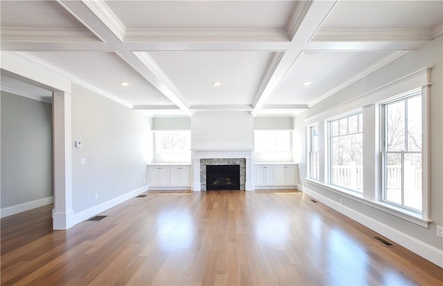 unfurnished living room featuring a stone fireplace, coffered ceiling, wood finished floors, and visible vents