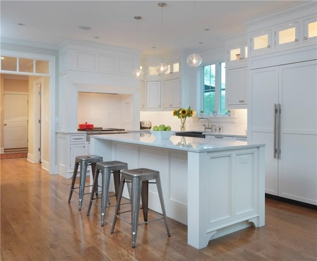 kitchen with crown molding, dark wood-style floors, white cabinetry, and a center island