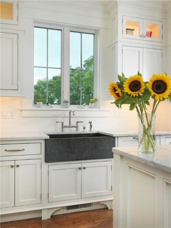 interior space with a wealth of natural light, visible vents, a sink, and backsplash