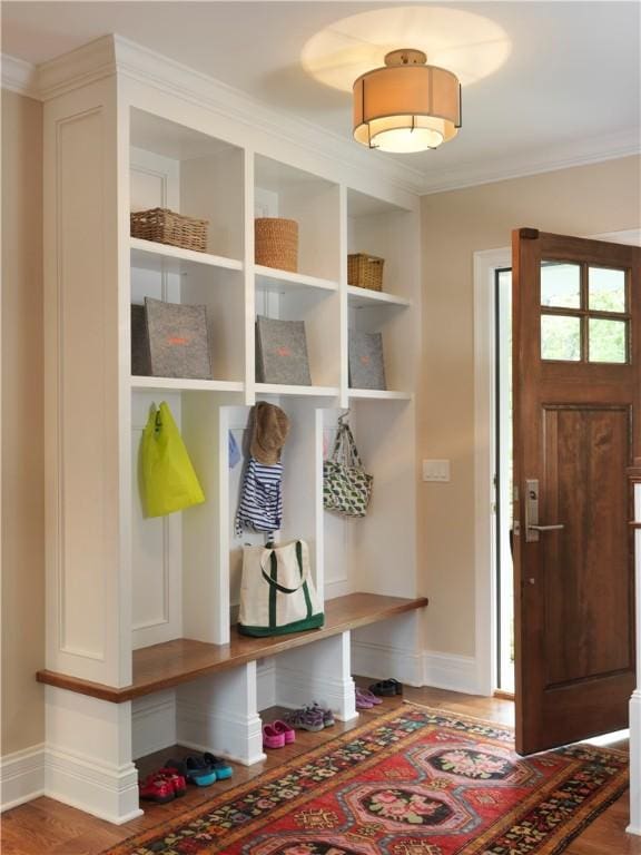 mudroom with baseboards, wood finished floors, and crown molding