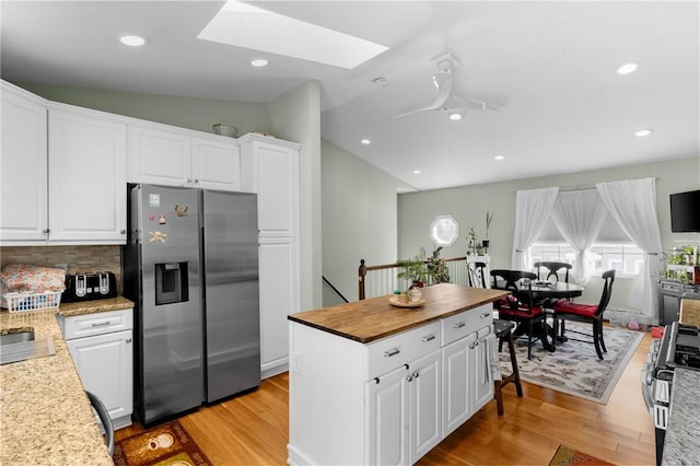 kitchen with appliances with stainless steel finishes, a wealth of natural light, and light wood-style floors