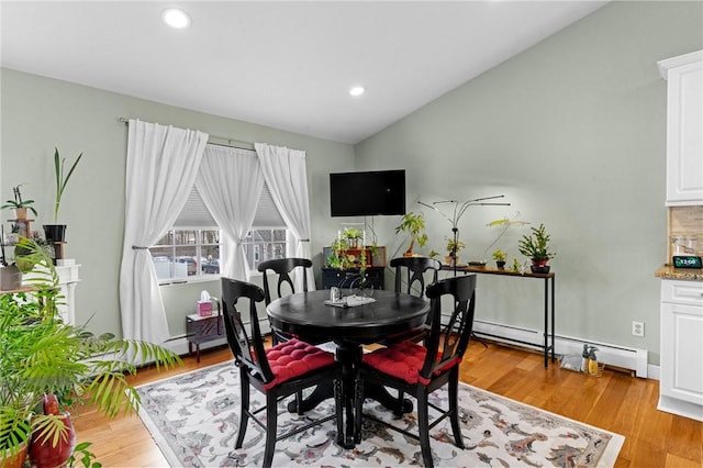 dining area featuring vaulted ceiling, recessed lighting, a baseboard radiator, and light wood-style floors