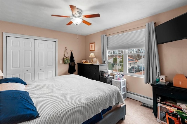 bedroom with carpet floors, a closet, baseboard heating, and a ceiling fan