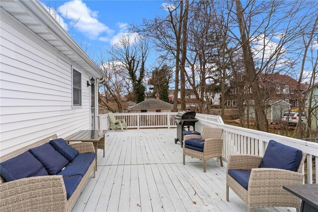 wooden terrace with grilling area and an outdoor hangout area