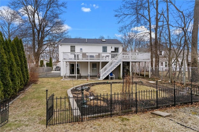 rear view of house with stairway, a lawn, a fenced backyard, and a wooden deck