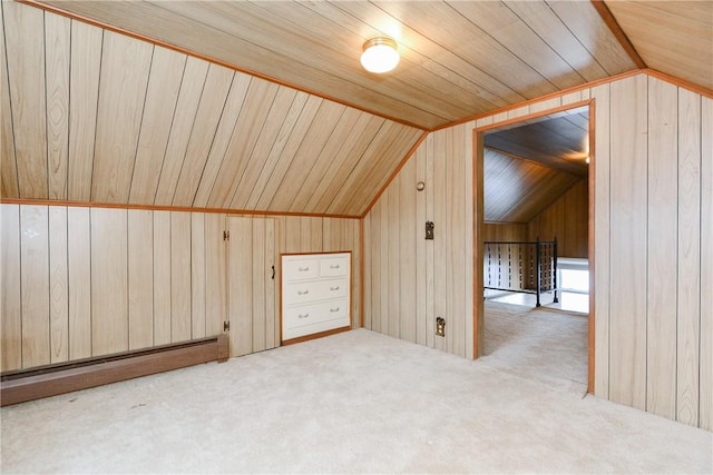 additional living space featuring lofted ceiling, wooden walls, a baseboard heating unit, and carpet flooring