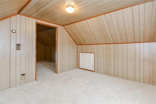 additional living space with lofted ceiling, wood walls, and carpet