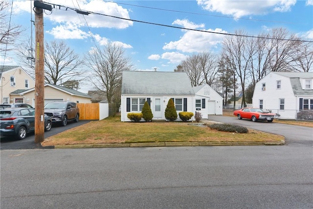 view of front of home featuring fence, aphalt driveway, and a front yard