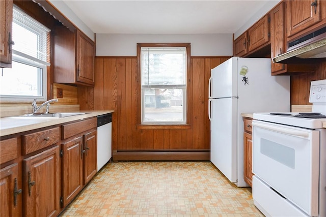 kitchen featuring white appliances, brown cabinets, wood walls, and baseboard heating