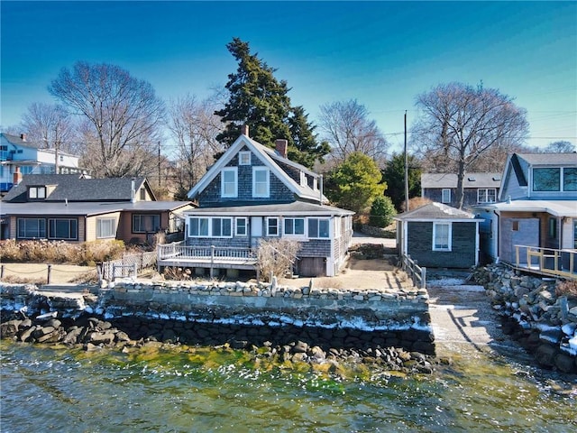 rear view of property featuring a chimney and a wooden deck