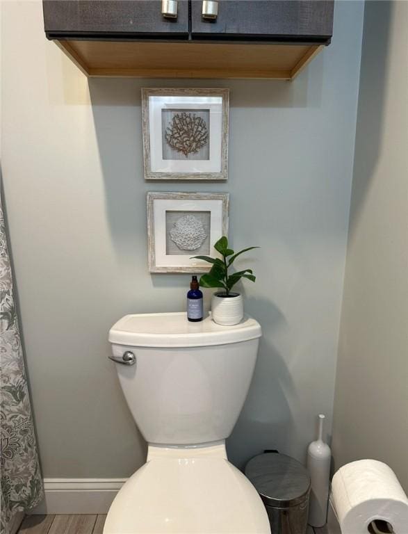 full bath featuring toilet, baseboards, and wood finished floors