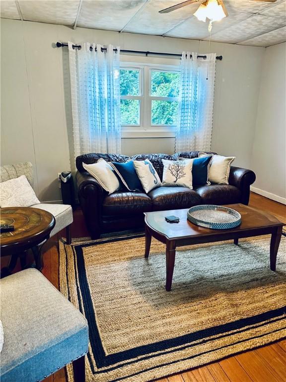 living room featuring ceiling fan, wood finished floors, and baseboards