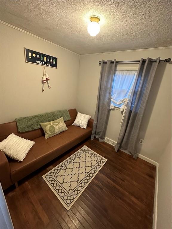 living area featuring visible vents, a textured ceiling, and wood finished floors