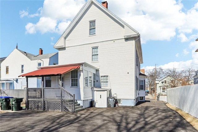 back of house with a residential view, a porch, and fence