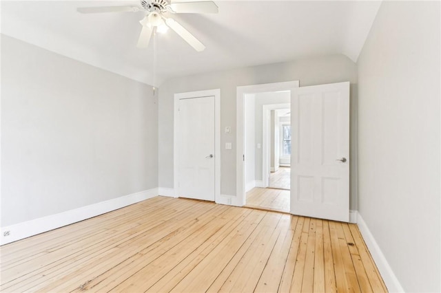 unfurnished room with baseboards, ceiling fan, vaulted ceiling, and hardwood / wood-style flooring