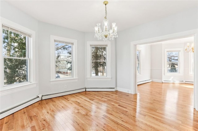 unfurnished dining area featuring a notable chandelier, light wood-style flooring, and baseboard heating