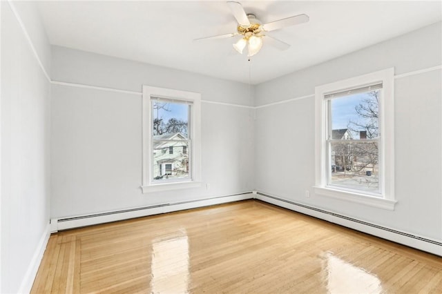 empty room with a baseboard radiator, wood finished floors, and a ceiling fan