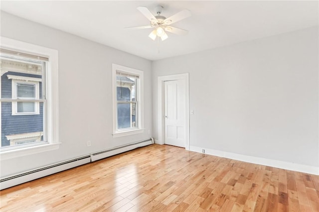 unfurnished room with a baseboard heating unit, baseboards, light wood-style floors, and a ceiling fan