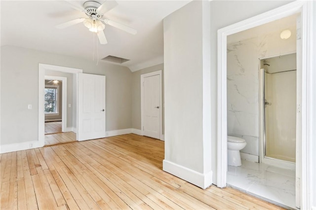 unfurnished bedroom featuring hardwood / wood-style flooring, a ceiling fan, baseboards, and ensuite bathroom