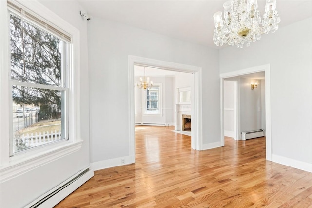 unfurnished dining area with a healthy amount of sunlight, a chandelier, and a baseboard radiator