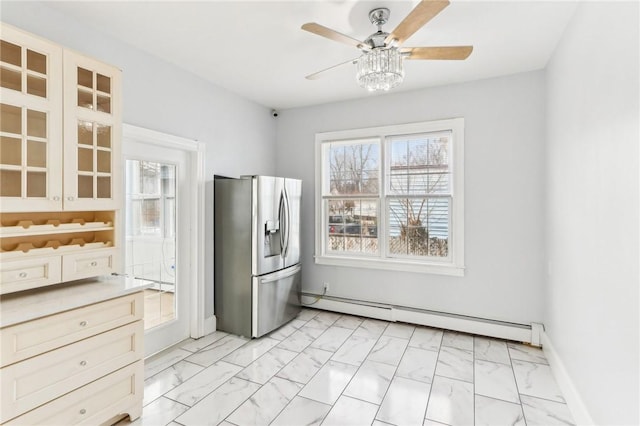 kitchen featuring marble finish floor, a ceiling fan, stainless steel refrigerator with ice dispenser, a baseboard radiator, and baseboards