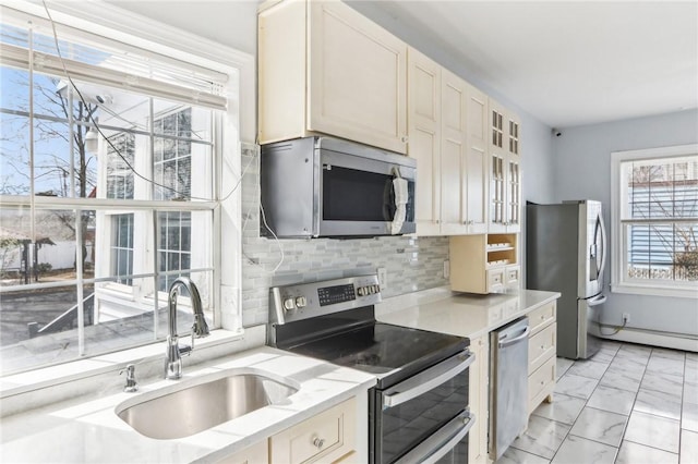 kitchen with a sink, decorative backsplash, glass insert cabinets, appliances with stainless steel finishes, and marble finish floor