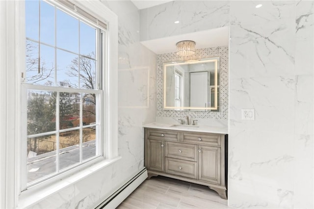 bathroom featuring a wealth of natural light, baseboard heating, and vanity