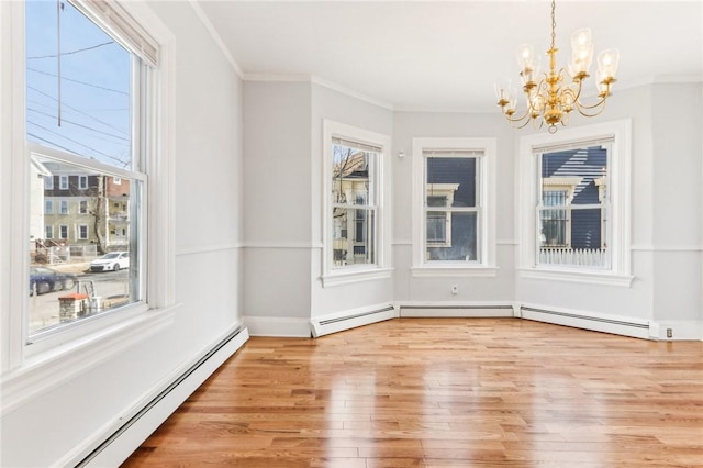 unfurnished dining area featuring ornamental molding, wood finished floors, a chandelier, and a baseboard radiator