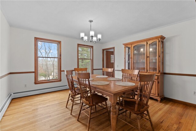 dining area featuring a chandelier, a baseboard radiator, baseboards, and light wood finished floors