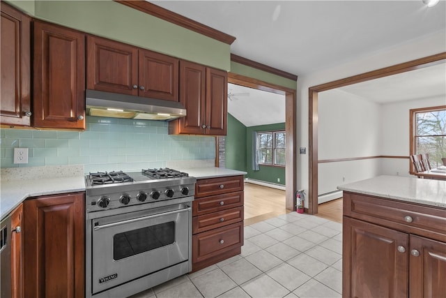 kitchen featuring a healthy amount of sunlight, under cabinet range hood, designer range, and a baseboard heating unit