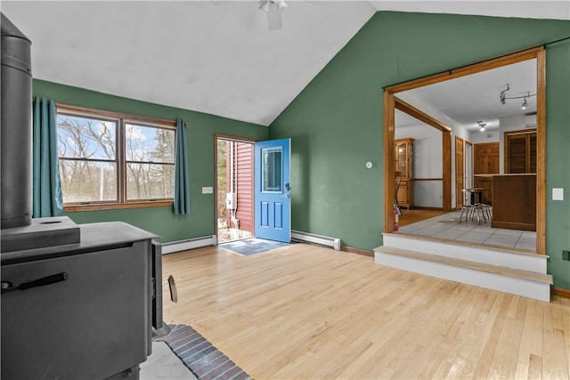 interior space featuring a baseboard radiator, wood finished floors, and a wood stove